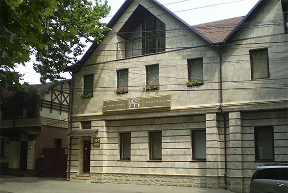 The exterior of Dent VIP dental clinic in Chișinău, showcasing a modern and welcoming building surrounded by greenery